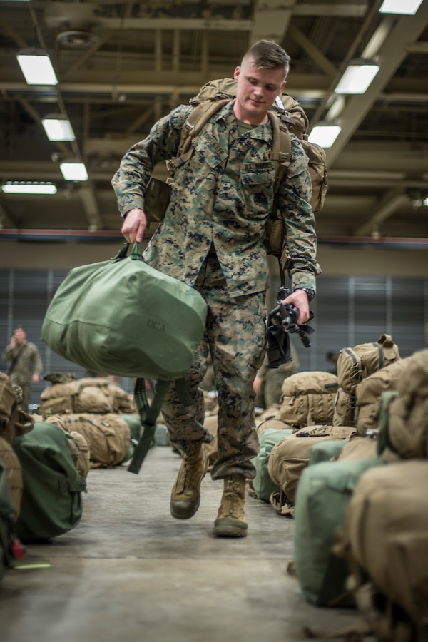 Lance Cpl. William Chelette, a field artillery radar operator with Headquarters Battery, 14th Marine Regiment, 4th Marine Division carries his gear to get weighed at Fort Worth, Texas, Feb. 23, 2019. Marines with 14th Marines are part of exercise Dynamic Front 19, a multinational exercise in Latvia, which includes approximately 3,820 participants from 29 nations. (U.S. Marine Corps photo by Cpl. Niles Lee)