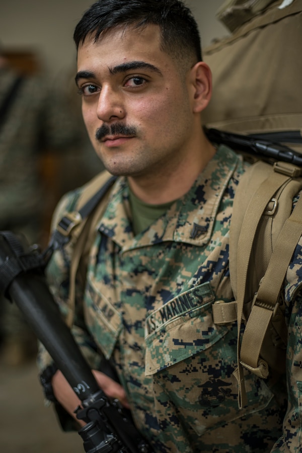Cpl. Eduardo Cuéllar, a fire direction control man with Headquarters Battery, 14th Marine Regiment, 4th Marine Division carries his gear to get weighed at Fort Worth, Texas, Feb. 23, 2019. Marines with 14th Marines are part of exercise Dynamic Front 19, a multinational exercise in Latvia, which includes approximately 3,820 participants from 29 nations. (U.S. Marine Corps photo by Cpl. Niles Lee)
