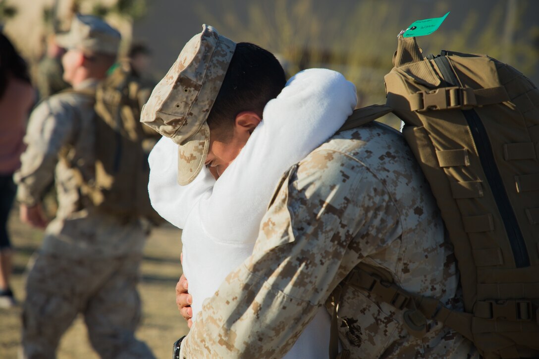 A Marine with 3rd Battalion, 4th Marines, 7th Marine Regiment, 1st Marine Division, hugs his mother during a homecoming ceremony at Victory Field on Marine Corps Air Ground Combat Center (MCAGCC), Twentynine Palms, Calif., March 8, 2019. The Marines and sailors returned from a six-month deployment to Kuwait. (U.S. Marine Corps photo by Pfc. Shane T. Beaubien)