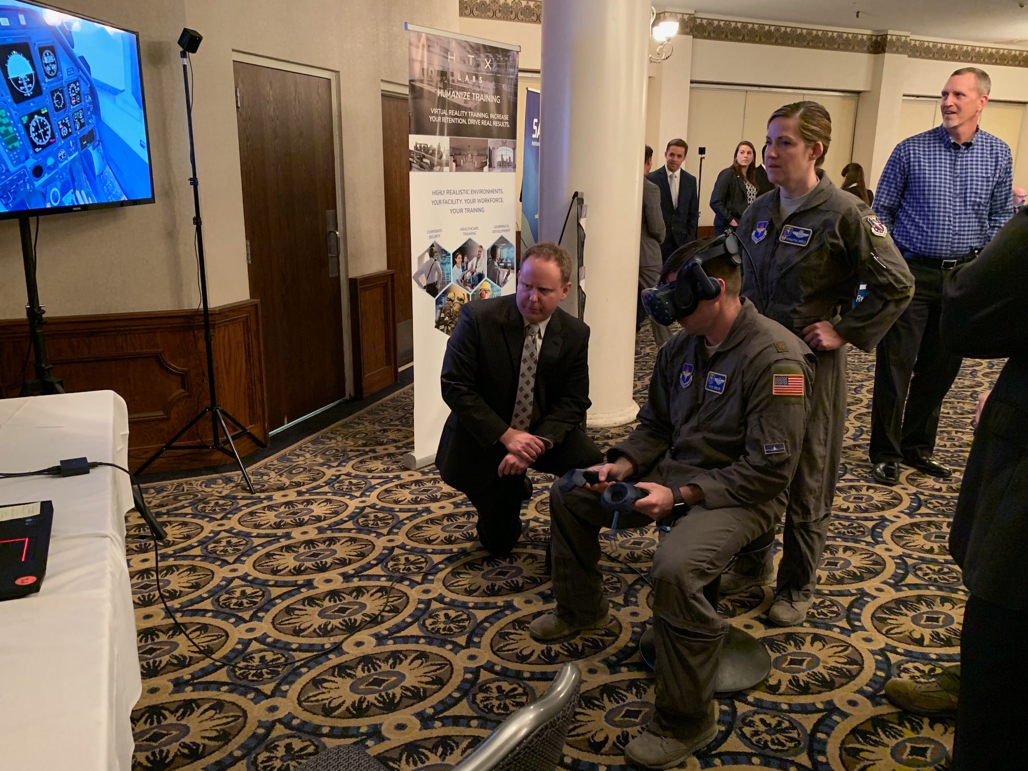 Col. Samantha Weeks (right), 14th Flying Training Wing commander, and Maj. Ryan Brewer (seated), 14th FTW SparkCell director, sample emergency procedures augmented-reality technology at the PTN Technology Expo at Joint Base San Antonio-Randolph, Texas, March 12, 2019.  Flying training wings will formally begin integrating innovations from PTN into the undergraduate pilot training curriculum beginning May 31, 2019.