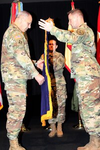 Gen. Gus Perna (left), commanding general of Army Materiel Command, assists in unfurling the AMC flag, along with IMCOM Command Sgt. Maj. Melissa A. Judkins and Lt. Gen. Bradley A. Becker, IMCOM commanding general. An assumption of authority ceremony was held March 8 at Joint Base Fort Sam Houston, Texas, to commemorate IMCOM becoming a major subordinate command of AMC.