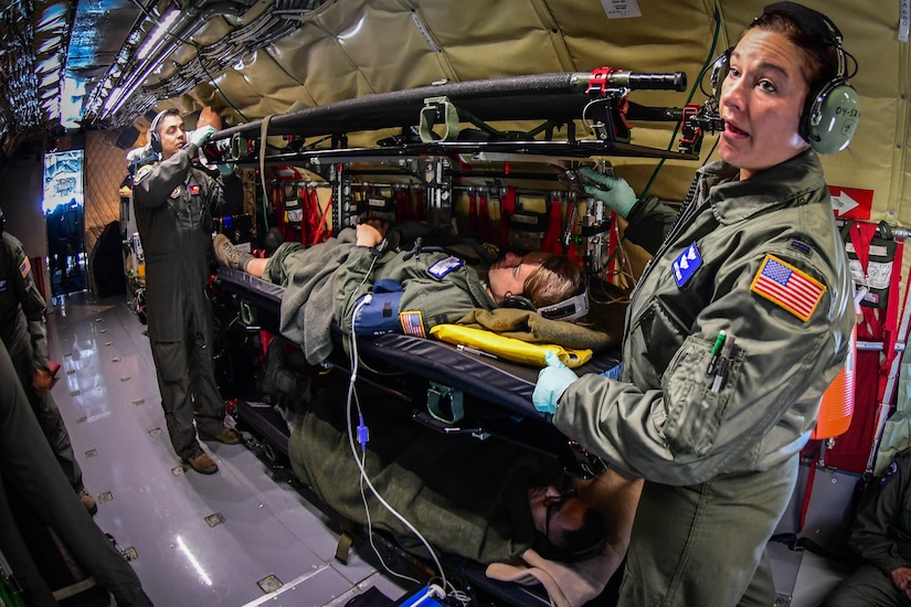 Air Force service members tend to a patient aboard an Air Force plane.