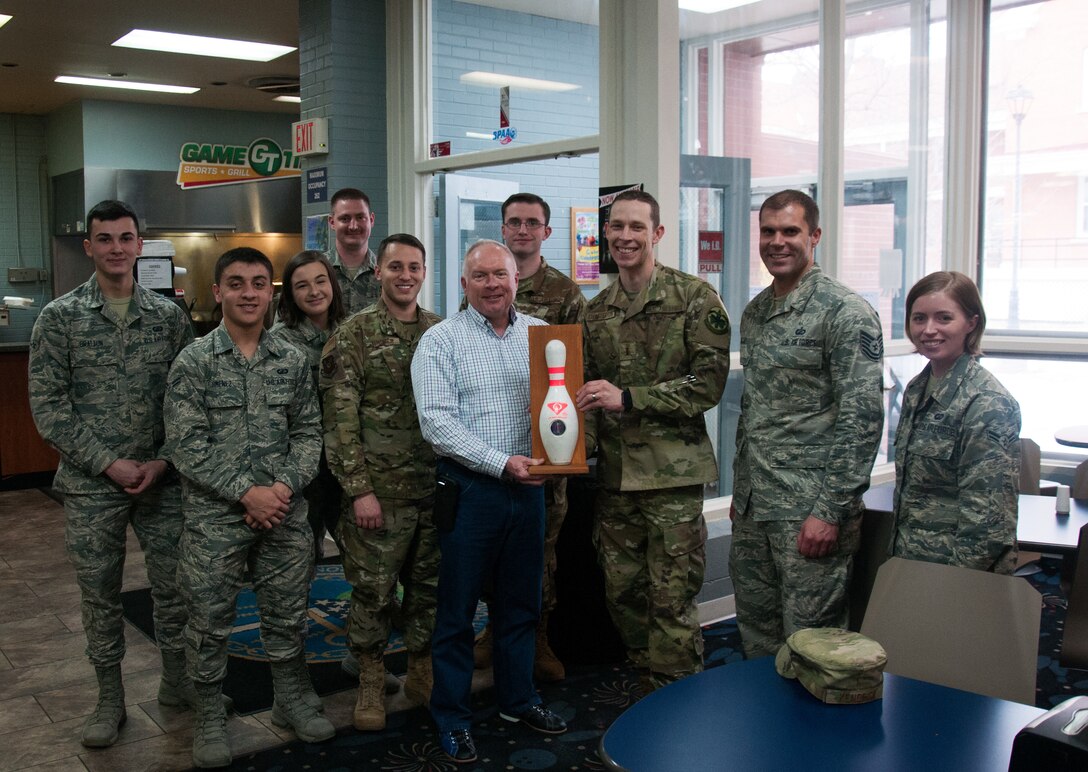 Maj. Gen. Fred Stoss, 20th Air Force commander, and members of the 90th Missile Wing finance flight hold the 20th Air Force Bowling Tournament trophy at F. E. Warren bowling alley on F. E. Warren AFB Wyo., March 8, 2019. 20th Air Force headquarters staff organized a bowling tournament in honor of the 75th anniversary of 20th Air Force. (U.S. Air Force photo by 1st Lt Ieva Bytautaite)