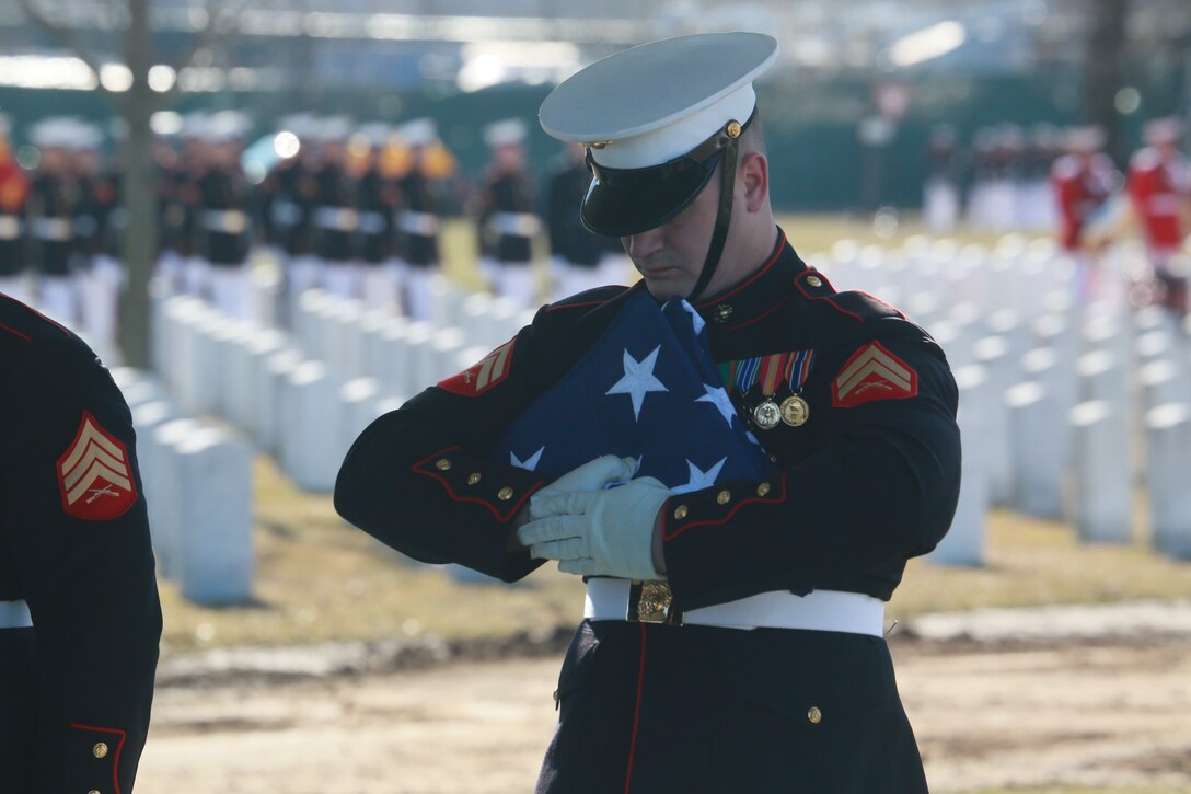 A Marine Body Bearer, Bravo Company, Marine Barracks Washington D.C., holds the National Flag during a full honors funeral for Lt. Gen. Leo Dulacki at Arlington National Cemetery, Arlington, Virginia, March 13, 2019.