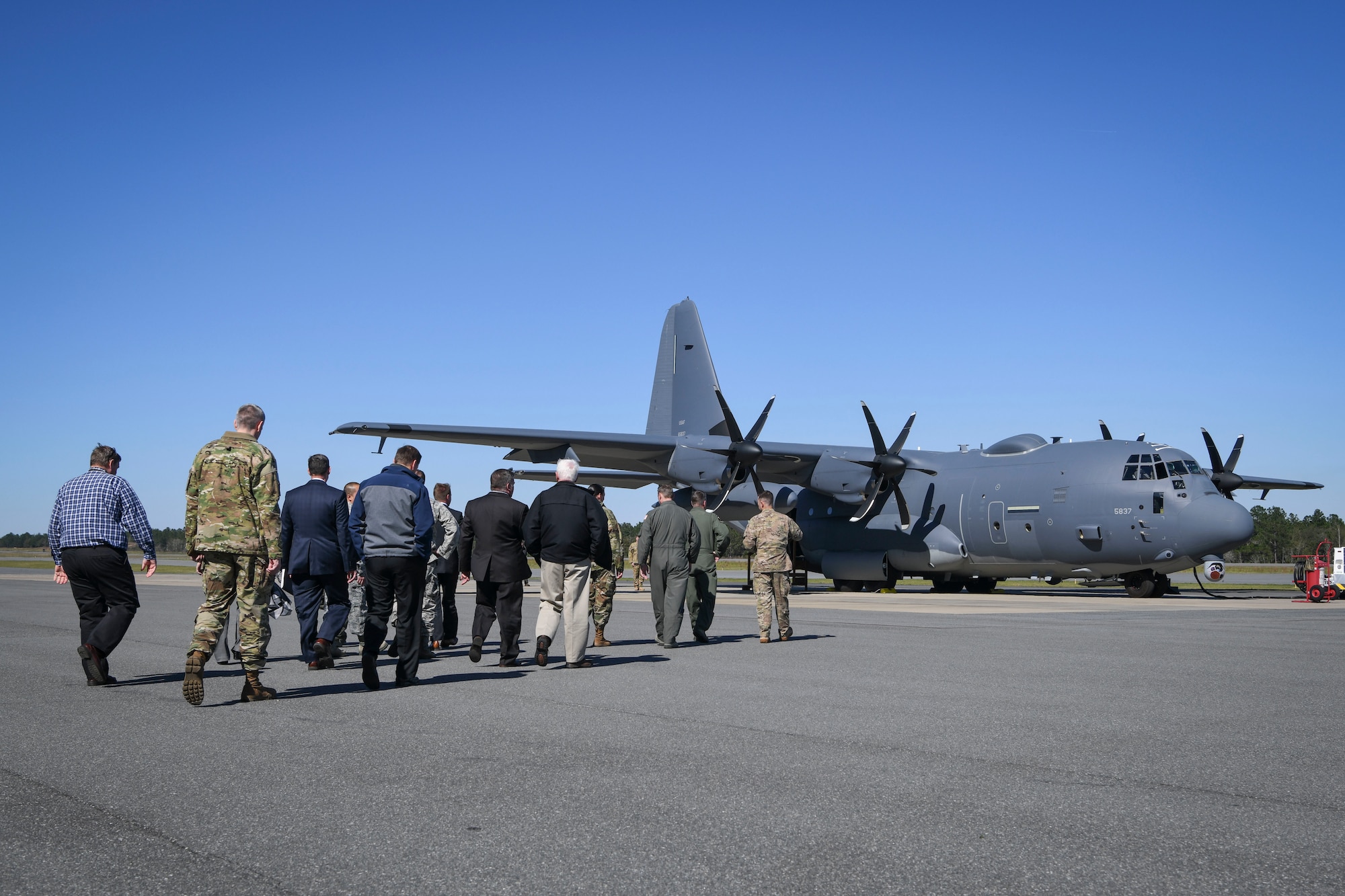 Airman and civilians walking out to aircraft