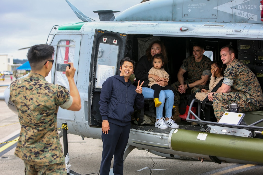 Local residents and 1st Marine Aircraft Wing service members pose for a photo aboard a static aircraft at the Futenma Flight Line Fair on Marine Corps Air Station Futenma, Mar. 10, 2019. The Futenma Flight Line Fair is an annual event that includes live music, games, and food vendors for visitors to enjoy. (U.S. Marine Corps photo by Lance Cpl. Marvin E. Lopez Navarro/Released)