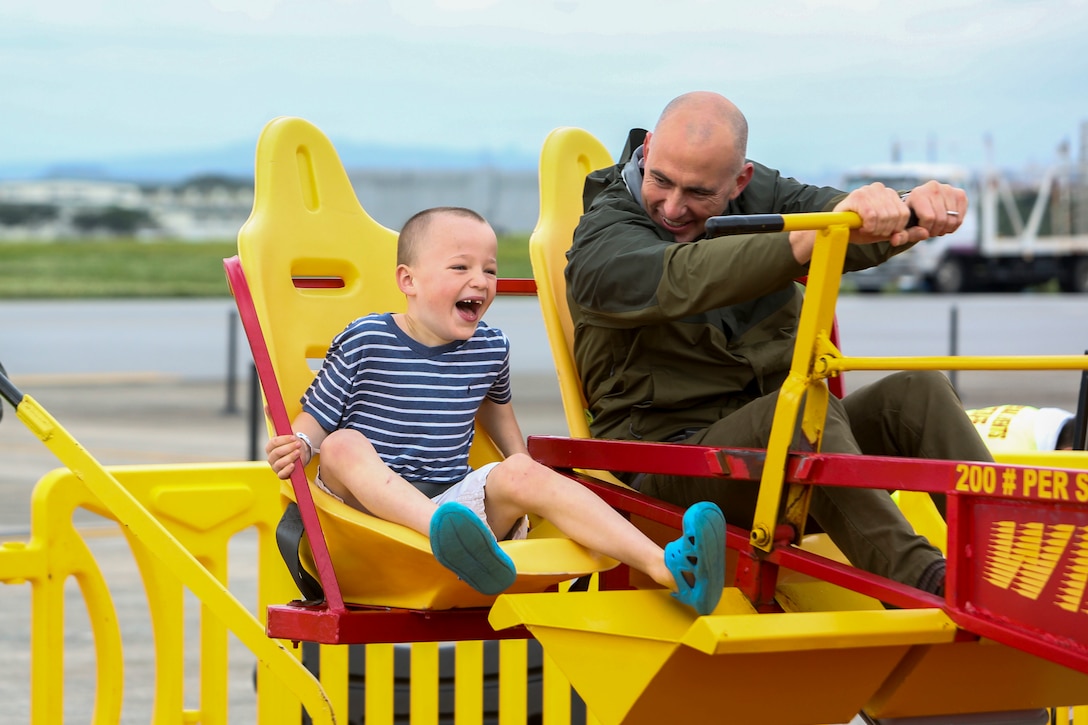 Members of the U.S military community enjoy carnival rides at the Futenma Flight Line Fair on Marine Corps Air Station Futenma, Mar. 10, 2019. The Futenma Flight Line Fair is an annual event that includes live music, games, and food vendors for attendees to enjoy. (U.S. Marine Corps photo by Lance Cpl. Marvin E. Lopez Navarro/Released)