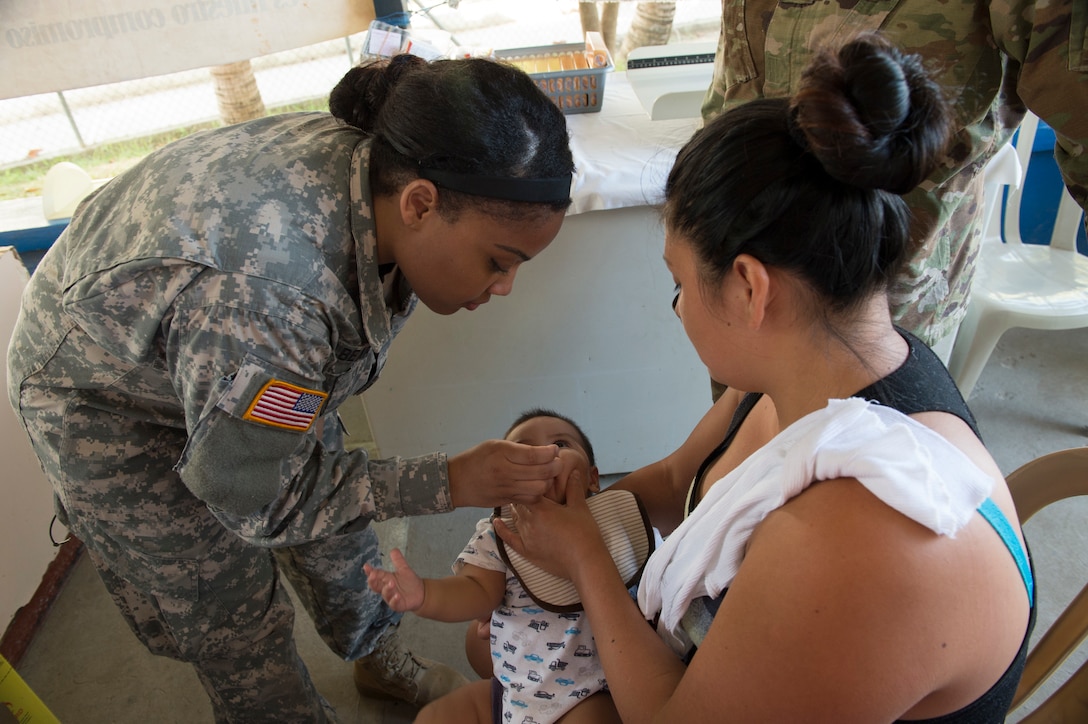 Specialist Gloria Galbearth, a U.S. Army Licensed Practical Nurse with the 139th Medical Brigade in Missouri, assists Guatemalan nurses with the inoculation of babies during a Medical Readiness Training Exercise (MEDRETE) at a health clinic in Flores, Peten, in Guatemala.