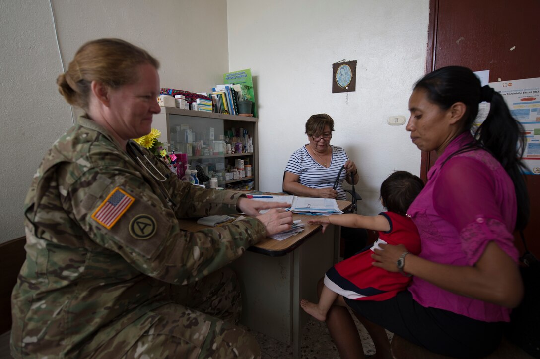 U.S. Army Maj. Adina Sanchez, a Nurse Practitioner with the 325th Combat Support Hospital  assists Guatemalan Dr. Jeanette Corzantes Barrios to evaluate patients during a Medical Readiness Training Exercise (MEDRETE) at a health clinic in Flores, Peten in Guatemala.