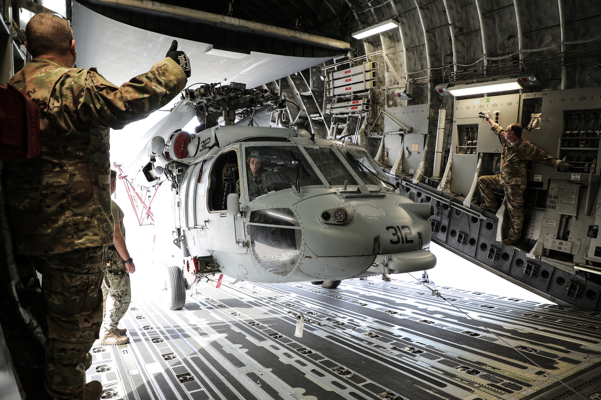 Navy personnel and loadmasters from the 89th Airlift Squadron load a MH-60S Seahawk helicopter onto a 445th Airlift Wing C-17 Globemaster III at Naval Base Coronado, California, Jan. 24, 2019. Members of the 445th Airlift Wing Operations Group performed their annual training at Naval Amphibious Base, Coronado and Marine Corps Air Station Miramar near San Diego, California Jan. 18-27, 2019. The training included water survival, Survival, Evasion, Resistance and Evasion, and low altitude flying. (U.S. Air Force photo/Master Sgt. Patrick O’Reilly)