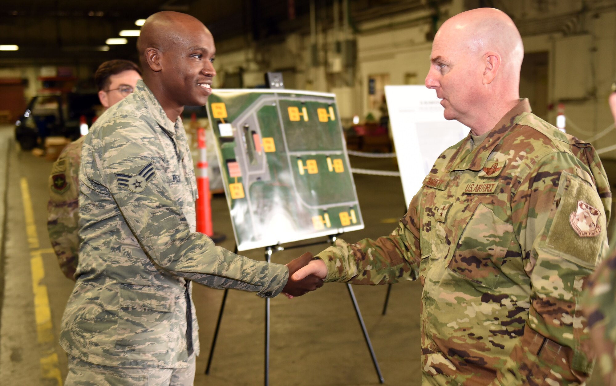 U.S. Air Force Maj. Gen. Sam Barrett, 18th Air Force commander, presents star performer U.S. Air Force Senior Airman Kalidon Bizimana, 60th Aerial Port Squadron Airman, with a coin at Travis Air Force Base, California, March 6, 2019. Barrett, along with his wife, Kelly and U.S. Air Force Chief Master Sgt. Chris Simpson, 18th Air Force command chief, toured the base March 4 to 8 as part of a scheduled visit. (U.S. Air Force photo by Airman 1st Class Christian Conrad)