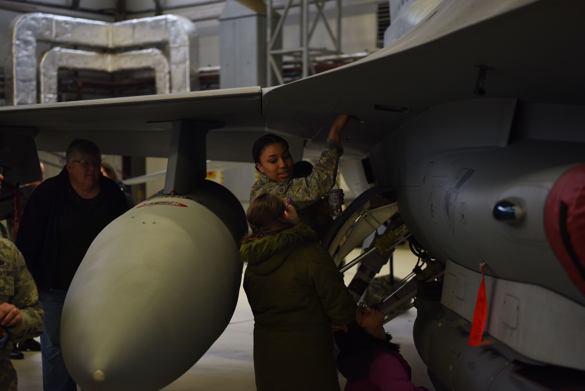 Airman 1st Class Kayla Harper, 52nd Maintenance Group crew chief, Spangdahlem Air Base, Germany shows a Kaiserslautern Military Community school student the specifications of an F-16 Fighting Falcon on Ramstein Air Base, Germany, March, 9, 2019. Harper showed her knowledge of the F-16 Fighting Falcon’s compartments, while leading a hands-on tour of the aircraft.