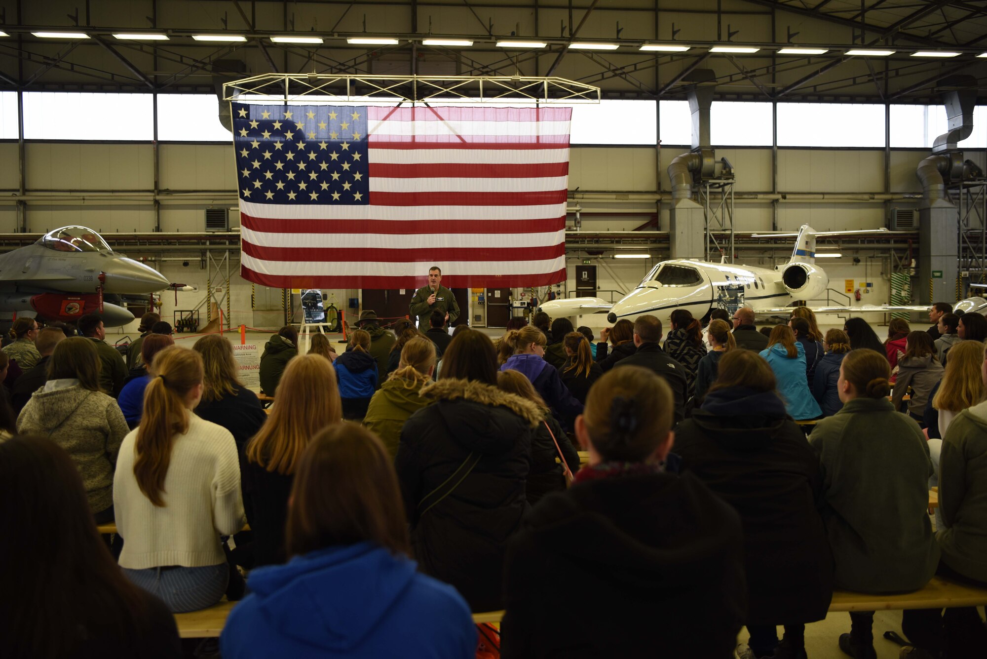 Brig. Gen. Mark R. August, 86th Airlift Wing commander speaks to a group of Kaiserslautern Military community children and parents during a Young Women in Aviation Day event on Ramstein Air Base, Germany, March, 9, 2019. August spoke to the students and highlighted accomplishments and contributions of women in the Air Force and in aviation.