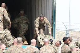 1st Lt. Scott Leduc, 1st Infantry Division Sustainment Brigade physician assistant, helps unload troop gear, at Ali Al Salem Air Base, Kuwait, Feb. 13, 2019. With all hands on deck, Leduc jumped in to help move the gear faster.