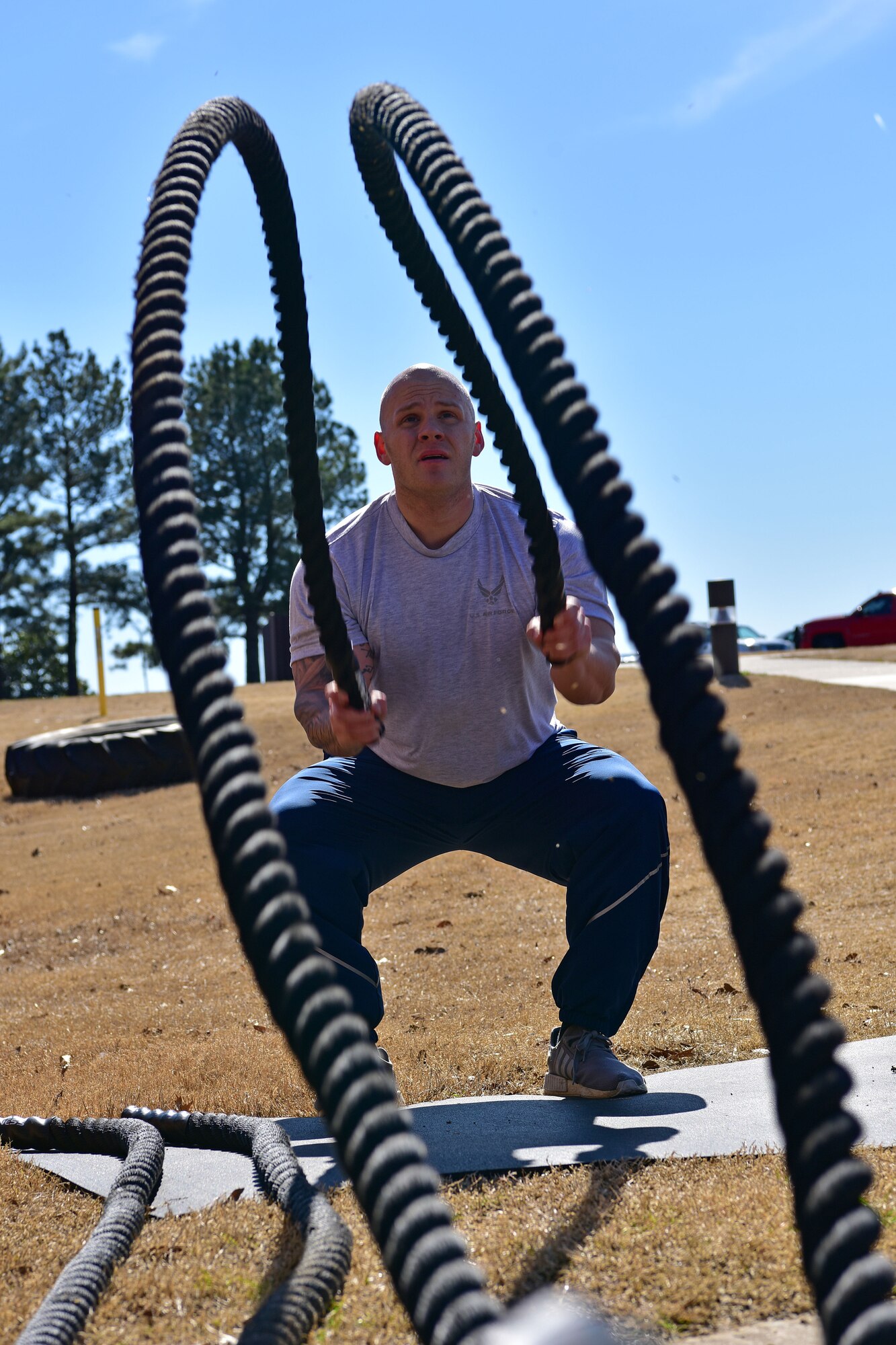 An Airman wings battle ropes while outside