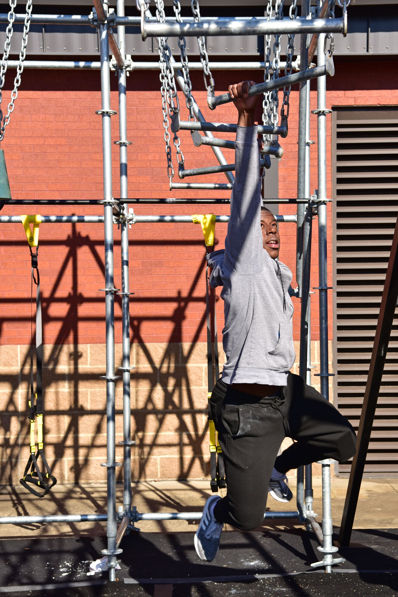 An Airman swings on a ladder