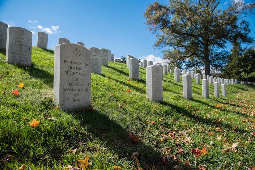 Lines of headstones on a grass-covered hill.