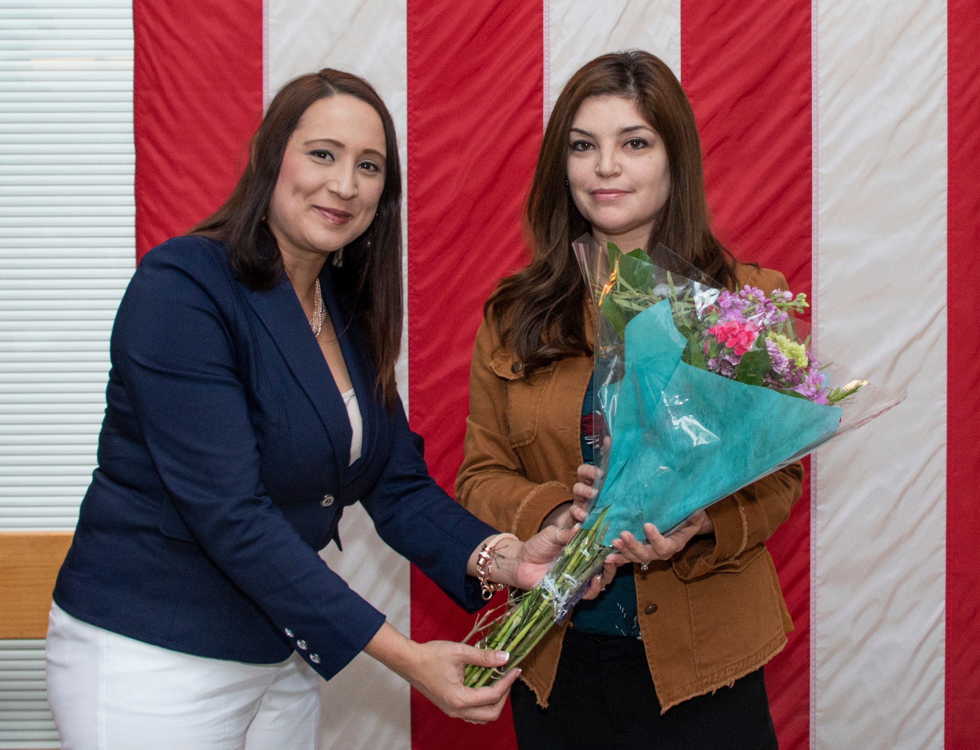 Najette Pinero, left, Airman and Family Readiness Center Community Readiness consultant, presents Jessica Moser, Key Spouse of the Year, 2018, a bouquet of flowers during the Key Spouse Recognition event at the 60th Maintenance Group atrium, Feb. 8, 2019 at Travis Air Force Base, California. Moser is the Key Spouse of the Year for 2018. The Key Spouse Program is an Air Force-wide volunteer program that builds and fosters support for military families through outreach education events and providing families a link to leadership. (U.S. Air Force photo by Heide Couch)