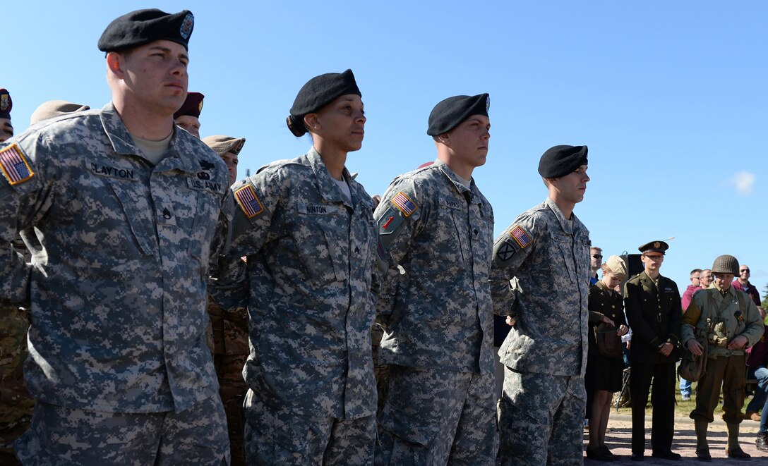 A formation of U.S Army Soldiers and World War II re-enactors in Sainte-Laurent-su-Mer, France