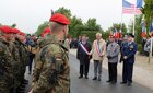 French, German and American dignitaries speak with German Army troops in Foucarville, France