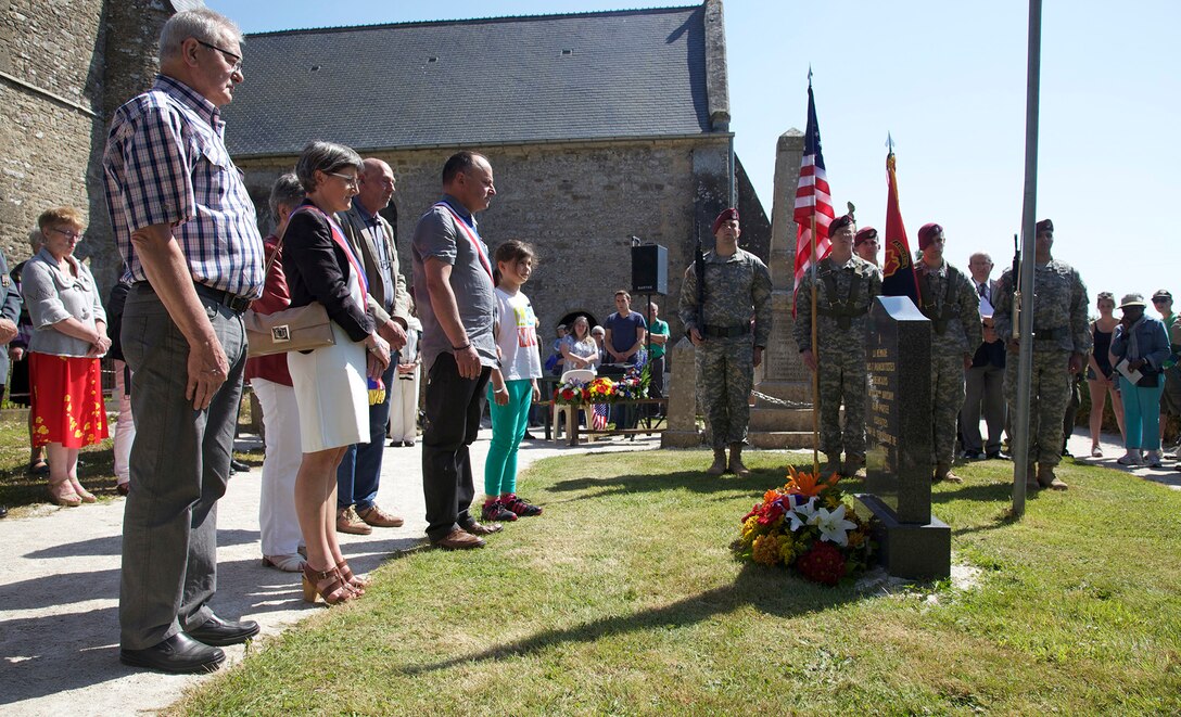 The mayor of Hemevez and members of his family lay a wreath at a 82nd Airborne Memorial during a ceremony at Hemevez,France