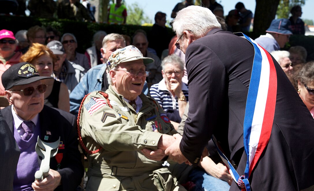 A mayor shakes hands of WWII veterans in Chef-du-Pont, France
