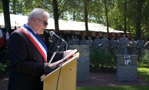 The mayor of Chef-du-Pont speaks during a WWII ceremony in Chef-du-Pont, France