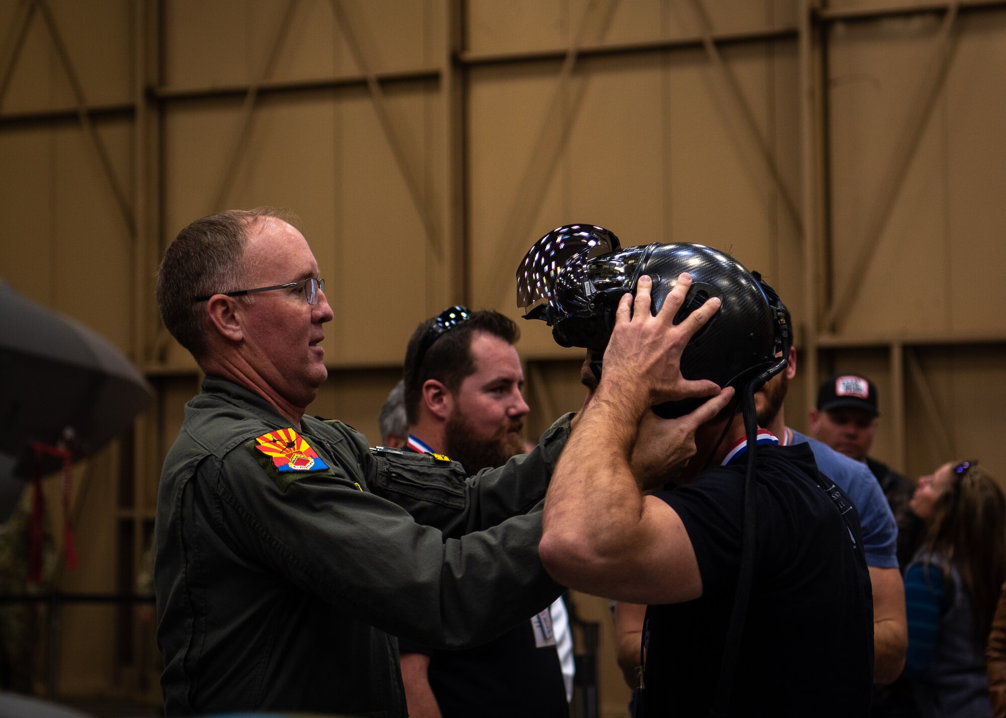 Brig. Gen. Todd Canterbury, 56th Fighter Wing commander, places his F-35A Lightning II helmet on an Airpower Foundation member during a base tour, March 8, 2019 at Luke Air Force Base, Ariz.