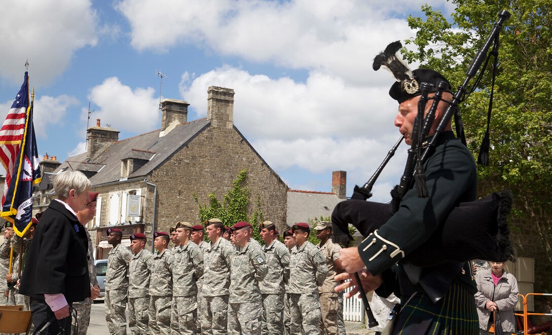 U.S. Soldiers stand in formation while bagpipes are played in Negreville, France