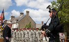 U.S. Soldiers stand in formation while bagpipes are played in Negreville, France