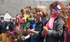 French school children wave French Flags during a ceremony in Negreville, France