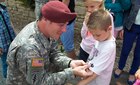 Master Sgt. Kyle Roscoe pins U.S. Army Jumpmaster wings to a French childs sleeve aftter a ceremony in Negreville, France