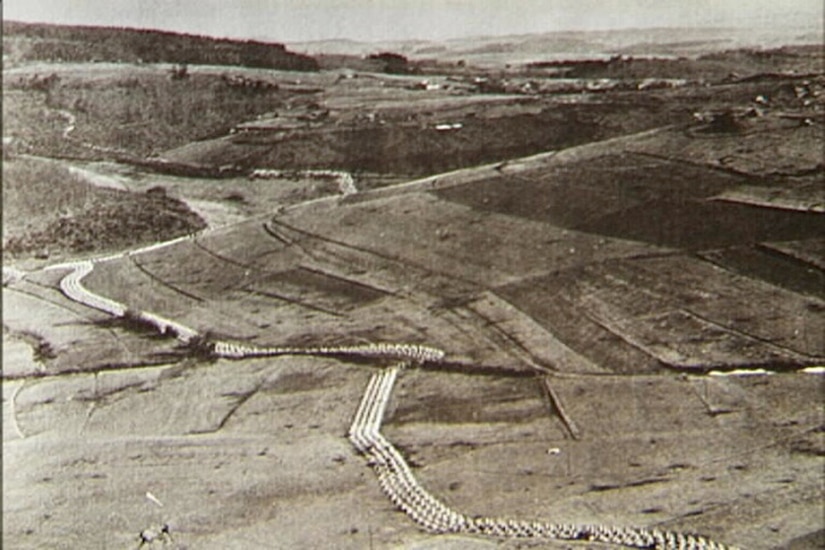 A black-and-white photo of a German hillside  covered with a line of defenses .