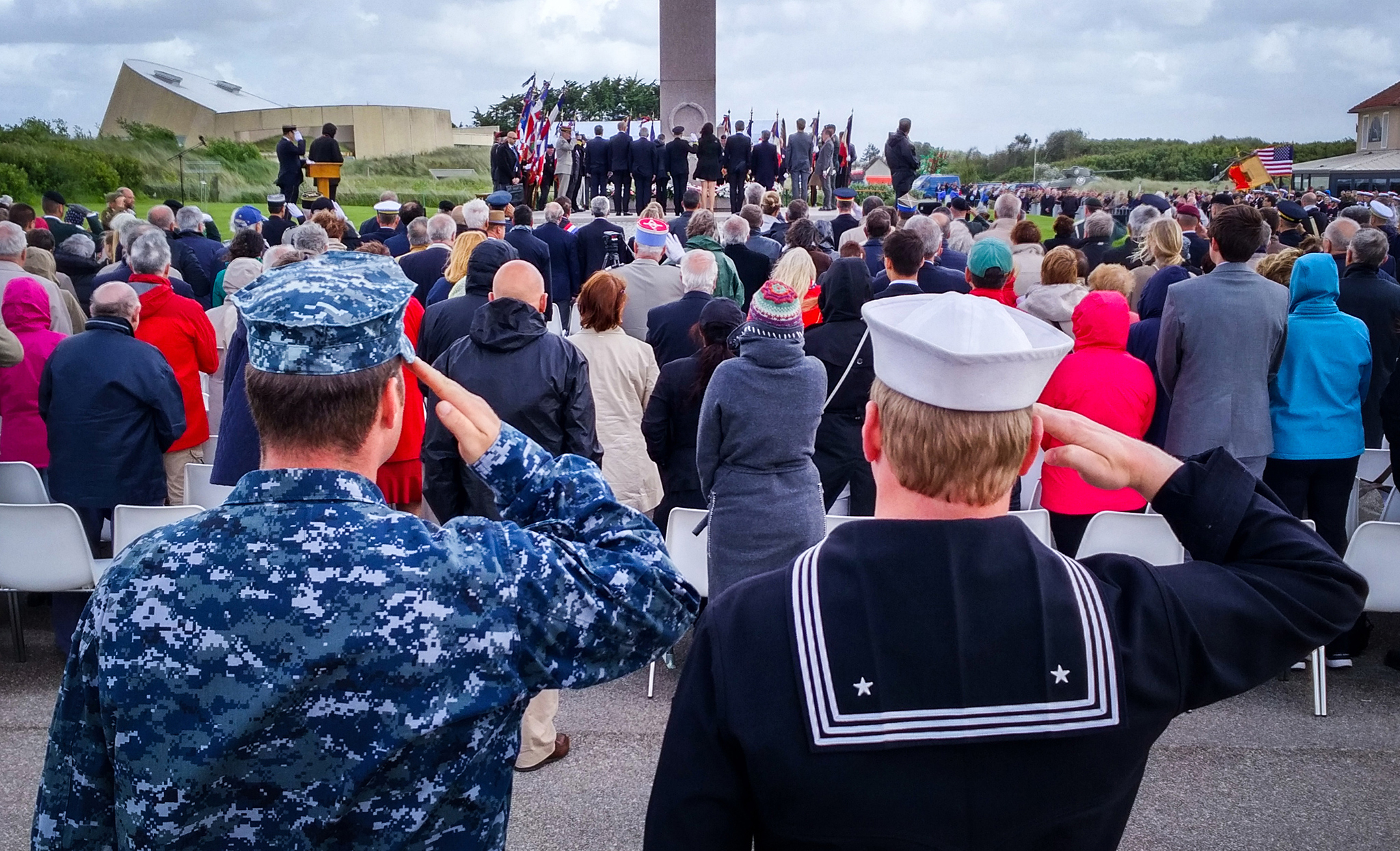 U S Navy Sailors salute during a ceremony in Sainte Marie du Mont France