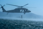 Service members practice helocasting by jumping into a lake from a UH-60 Blackhawk at Lake Ilopango, El Salvador, March 7, 2019.