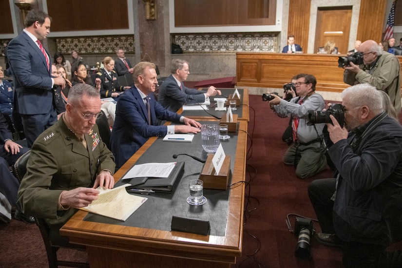 Photographers take pictures of Marine Corps Gen. Joe Dunford, Acting Defense Secretary Patrick M. Shanahan and David L. Norquist at a table.