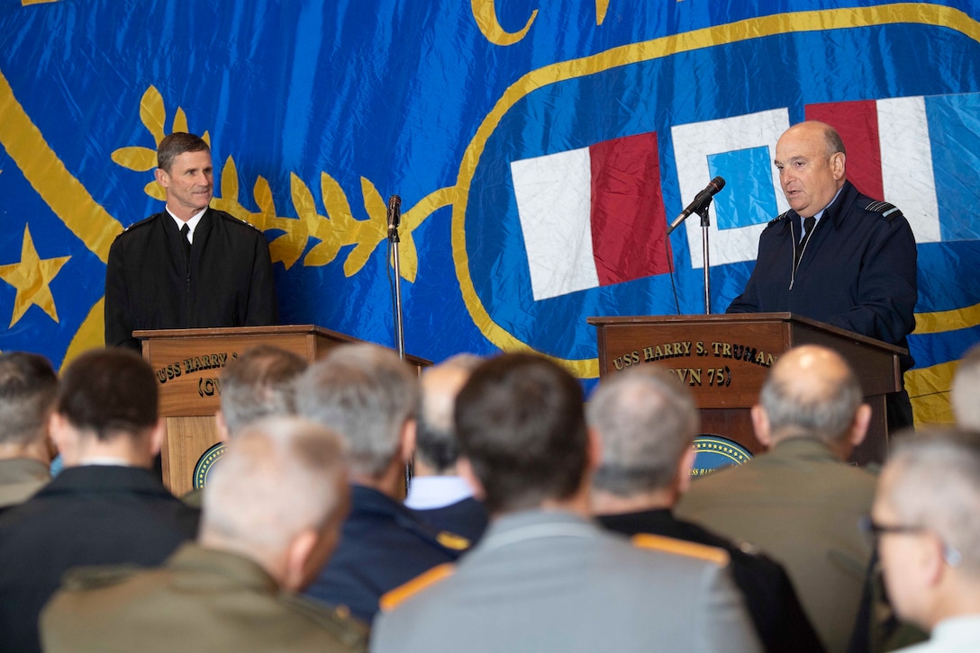 Two NATO military officers discuss naval operations.