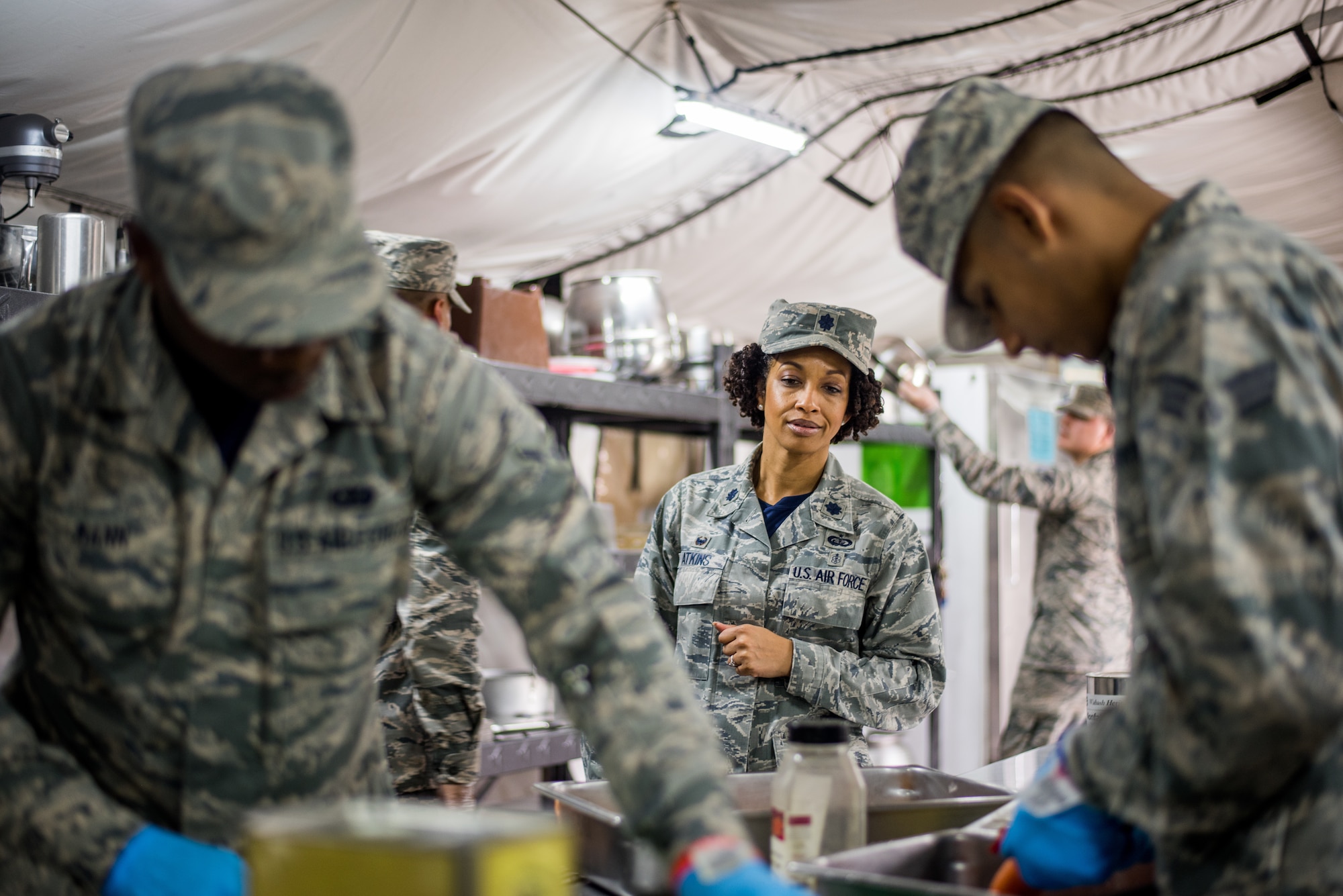 Lt. Col. Joy Atkins, 512th Memorial Affairs Squadron commander, observes the 512th MAS cooking team as they prepare food during the John L. Hennessy food service competition at Dobbins Air Reserve Base, Georgia, March 9, 2019. The 512th MAS cooking team were tasked with serving an appetizer, three entrées and dessert as a part of the competition rules. (U.S. Air Force photo by Staff Sgt. Damien Taylor)