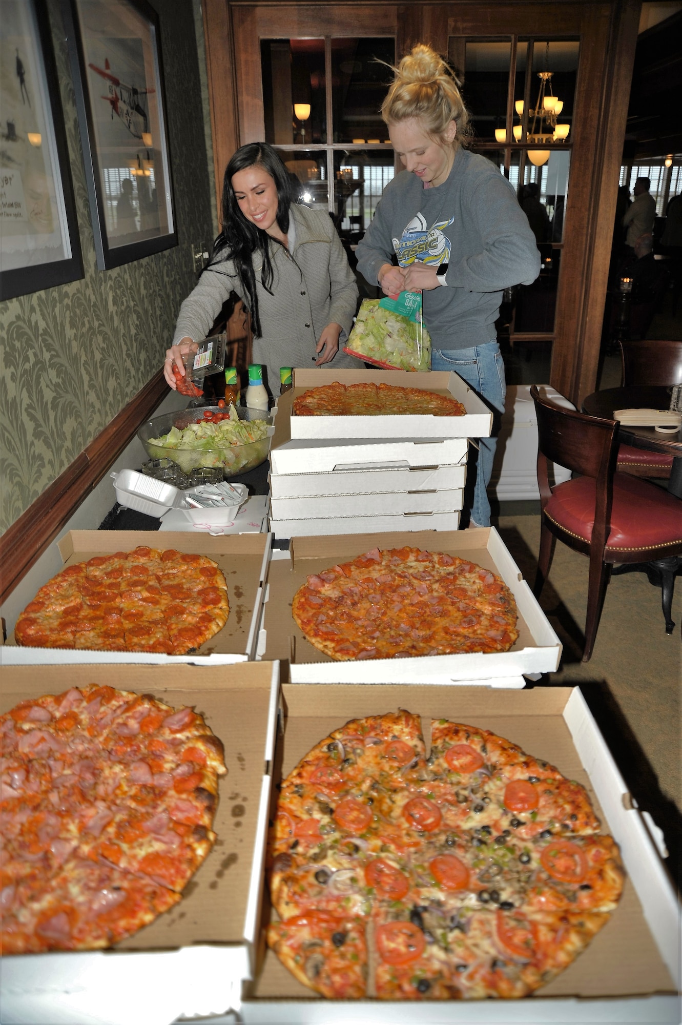 Second Lieutenants Natalie Seitz and Silvia Seraly set up the food for the summit ice-breaker dinner held March 4 in Fredericksburg. The lieutenants are remotely piloted aircraft students assigned to the 340th FTG while they wait for their class start date. (U.S. Air Force photo)