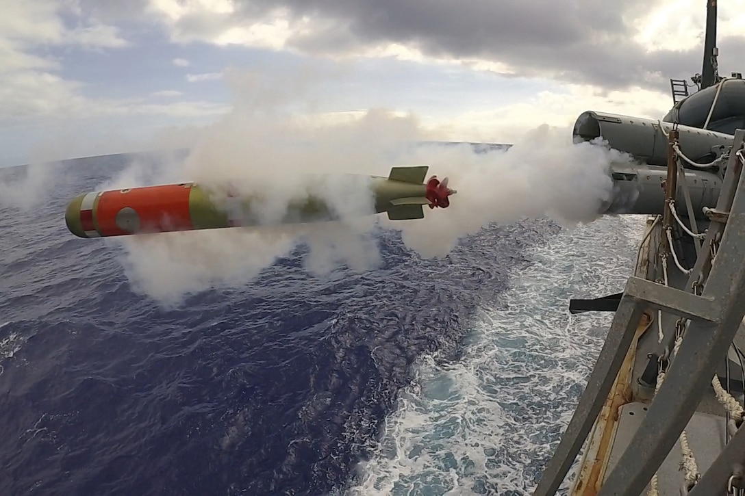 A torpedo launches from a military ship.