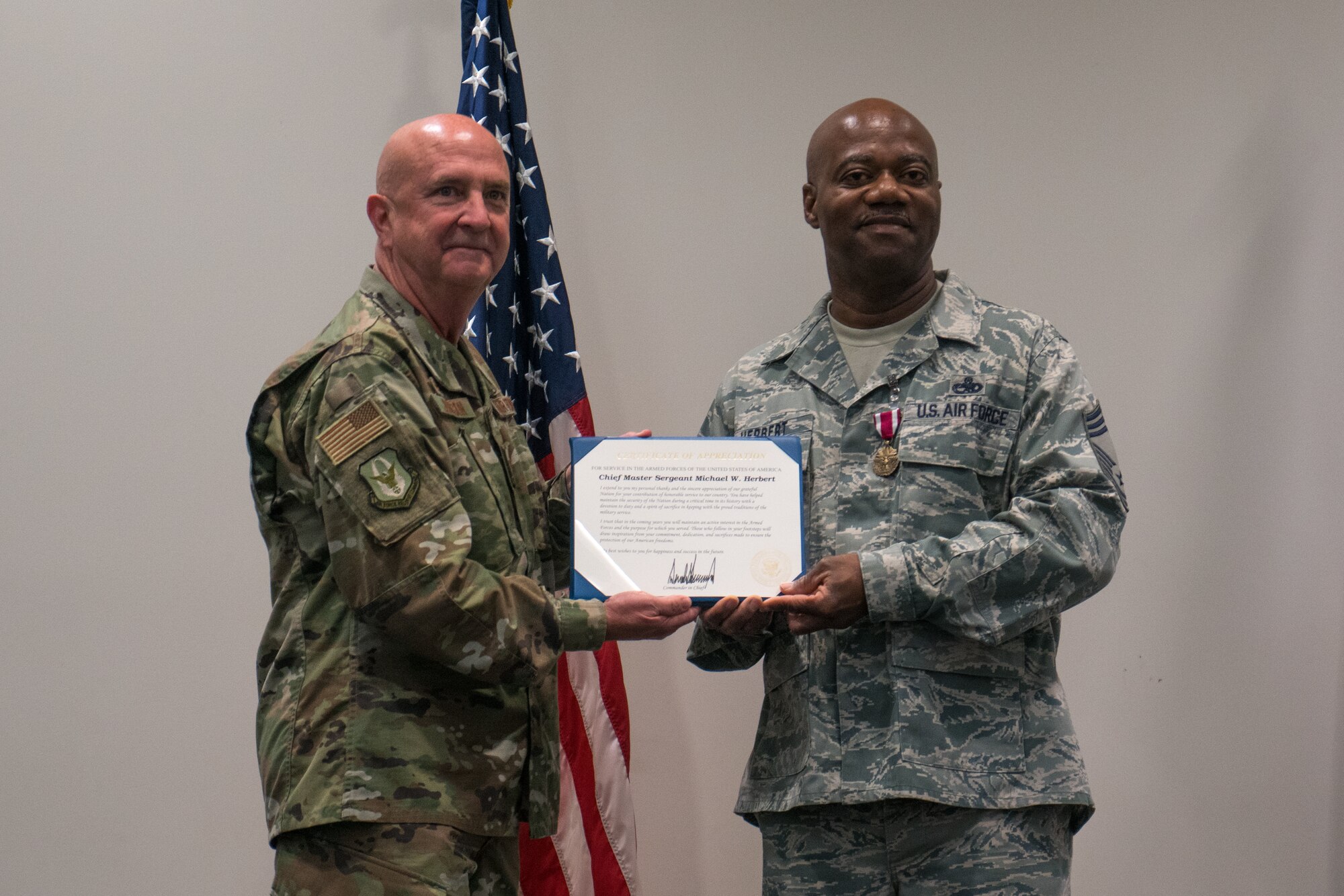 Col. Jay Johnson, 403rd Maintenance Group commander, presents Chief Master Sgt. Michael Herbert, 403rd Aircraft Maintenance Squadron superintendent, with his Appreciation Certificate for his military service during his retirement ceremony held at the Roberts Maintenance Facility March 9. (U.S. Air Force photo by Staff Sgt. Shelton Sherrill)