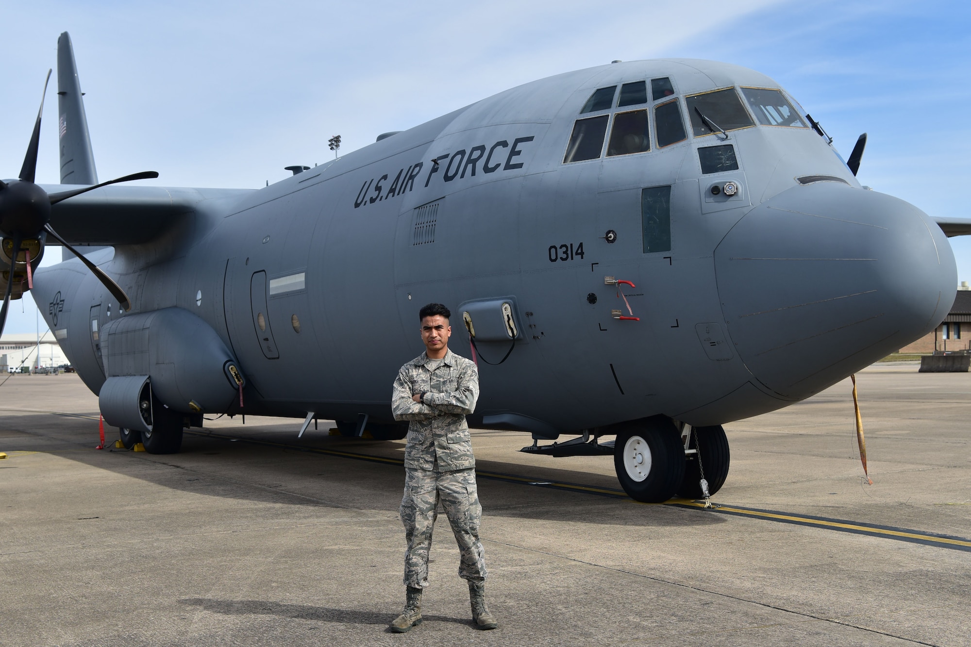 Airman poses in fron of a C-130J.