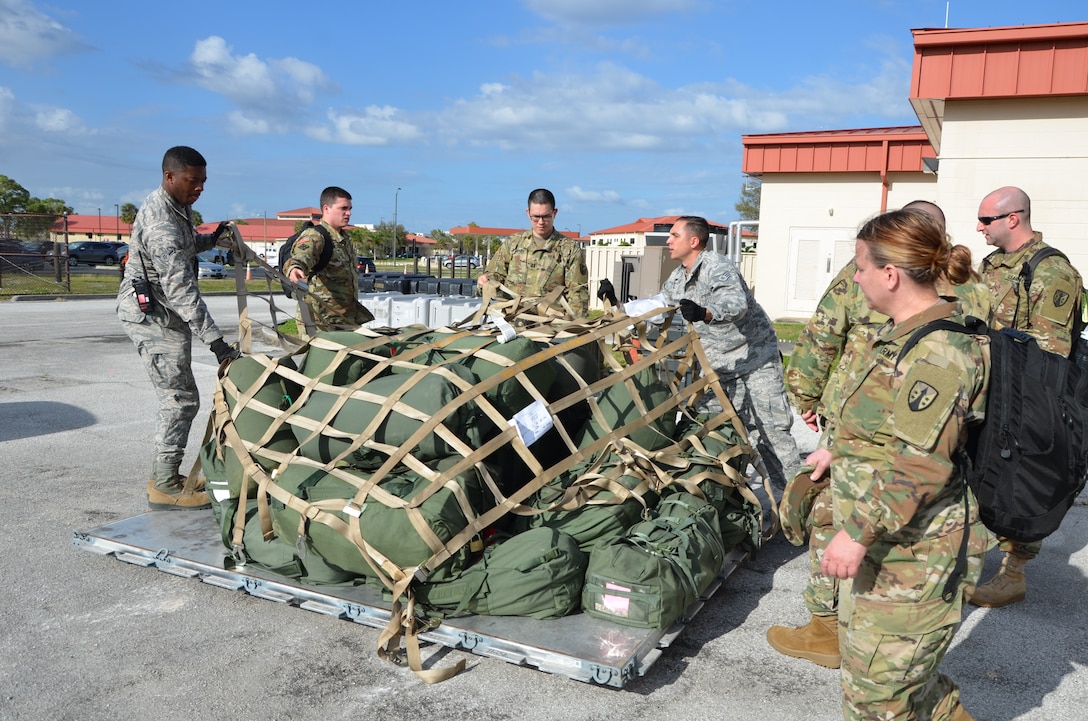 Soldiers with the 1st and 2nd Logistics Civil Augmentation Program Support Battalions from Fort Belvoir, Virginia and Air Force Soldiers stationed at MacDill Air Force Base uncrate cargo upon their arrival to conduct a mobilization exercise.