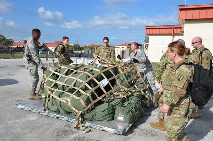 Soldiers with the 1st and 2nd Logistics Civil Augmentation Program Support Battalions from Fort Belvoir, Virginia and Air Force Soldiers stationed at MacDill Air Force Base uncrate cargo upon their arrival to conduct a mobilization exercise.