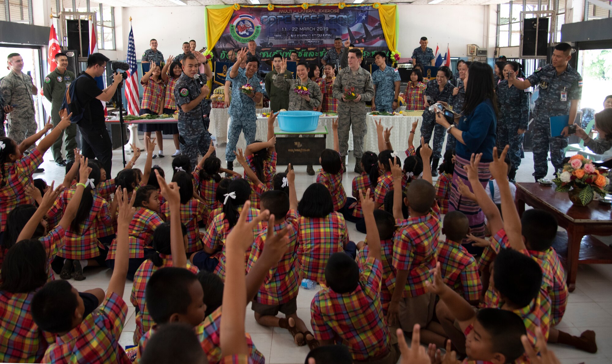 U.S., Royal Thai, and Singaporean Airmen participate in a team-building competition with Ban PaLai school kids during a COPE Tiger 2019 cultural exchange at Korat, Thailand, March 13, 2019.