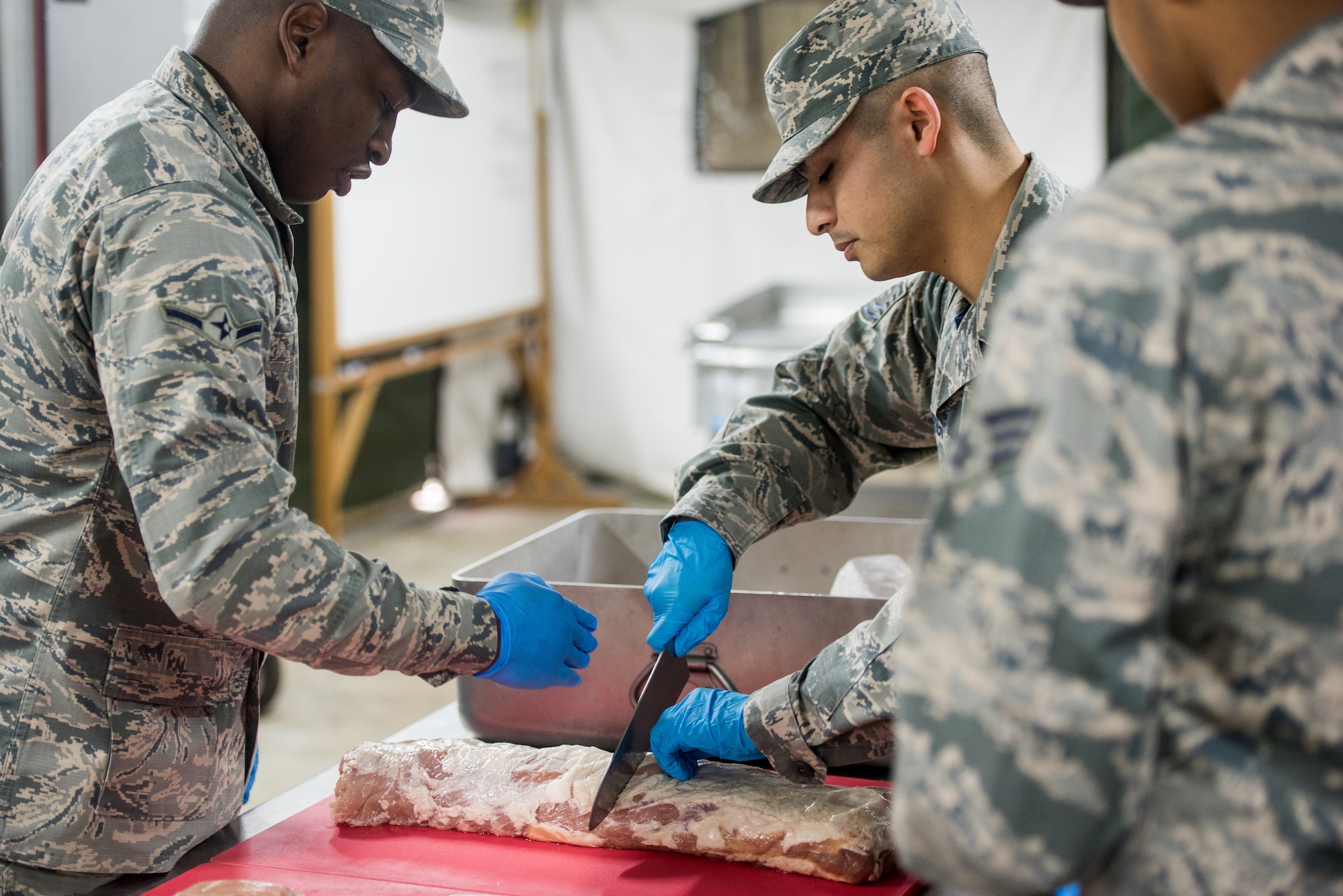 Airman Brandon Mann, 512th Memorial Affairs Squadron food specialist, and Tech Sgt. Cody Rodrigues, 512th MAS unit deployment manager, prep food during the 2019 John L. Hennessy competition at Dobbins Air Reserve Base, Georgia, March 9, 2019. The 512th MAS cooking team was tasked with preparing three entrées to be evaluated by the competition judges. (U.S. Air Force photo by Staff Sgt. Damien Taylor)