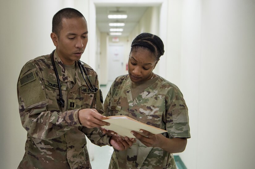 U.S. Army Capt. Clark Lomboy, left, Area Support Group - Qatar (ASG-QA) family nurse practitioner from Camp As Sayliyah (CAS), Qatar, and U.S. Air Force Tech. Sgt. Marquita Moore, 379th Expeditionary Medical Group (EMDG) optometry NCO in charge from Al Udeid Air Base (AUAB), Qatar, discuss patient appointment information March 9, 2019, at CAS. Moore and Lt. Col. Peter Carra, 379th EMDG optometry officer in charge, travel to CAS once a week to provide eye care for Soldiers who, in turn, fabricate glasses prescribed for Airmen at AUAB and servicemembers at other deployed locations throughout U.S. Central Command.  (U.S. Air Force photo by Tech. Sgt. Christopher Hubenthal)