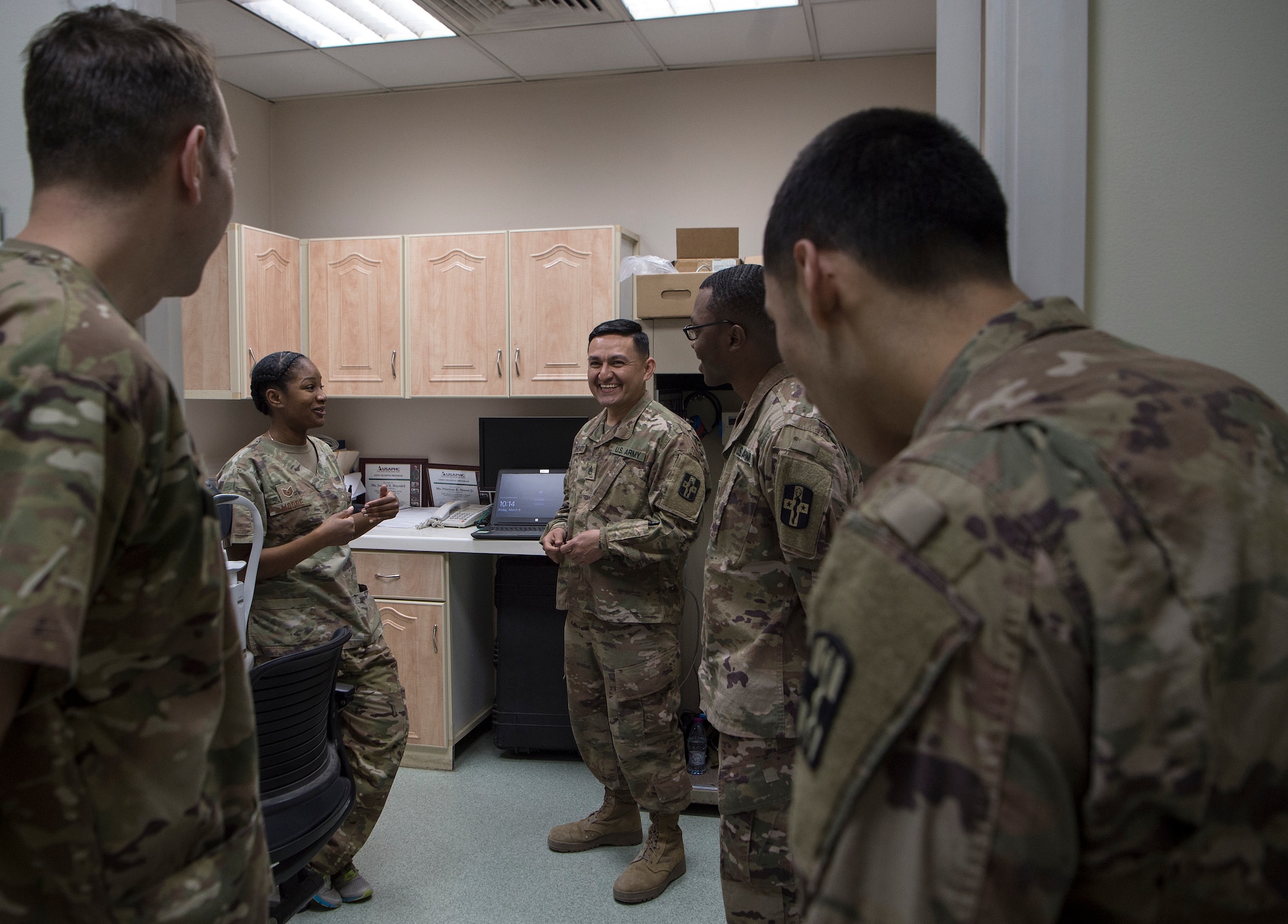 U.S. Air Force Tech. Sgt. Marquita Moore, center left, 379th Expeditionary Medical Group (EMDG) optometry NCO in charge and U.S. Air Force Lt. Col. Peter Carra, left, 379th EMDG optometry officer in charge from Al Udeid Air Base (AUAB), Qatar, talk with U.S. Army optical laboratory specialists of Area Support Group - Qatar (ASG-QA) from Camp As Sayliyah (CAS), Qatar, prior to a patient appointment March 9, 2019, at CAS. Moore and Carra travel to CAS once a week to provide eye care for Soldiers who, in turn, fabricate glasses prescribed for Airmen at AUAB and servicemembers at other deployed locations throughout U.S. Central Command.  (U.S. Air Force photo by Tech. Sgt. Christopher Hubenthal)