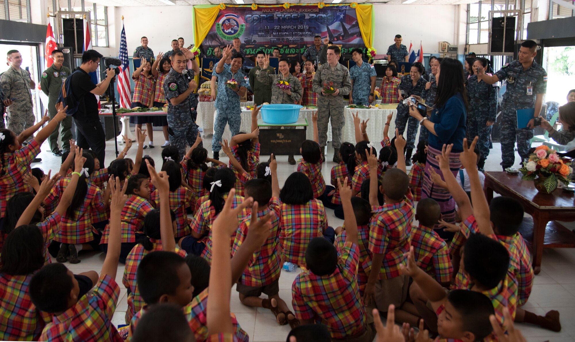 U.S., Royal Thai, and Singaporean Airmen participate in a team-building competition with Ban PaLai school kids during a COPE Tiger 2019 cultural exchange at Korat, Thailand, March 13, 2019.