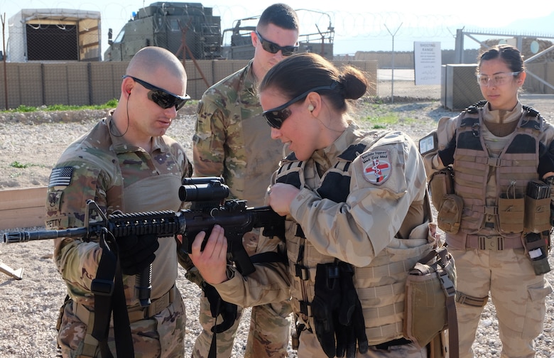 Staff Sergeant (P) Andrew Pretty explains the bold mechanism of the M4 rifle to a Belgian Role 2 Nurse during the event.
